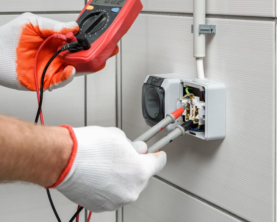 Test électrique sur une prise fixée sur du carrelage