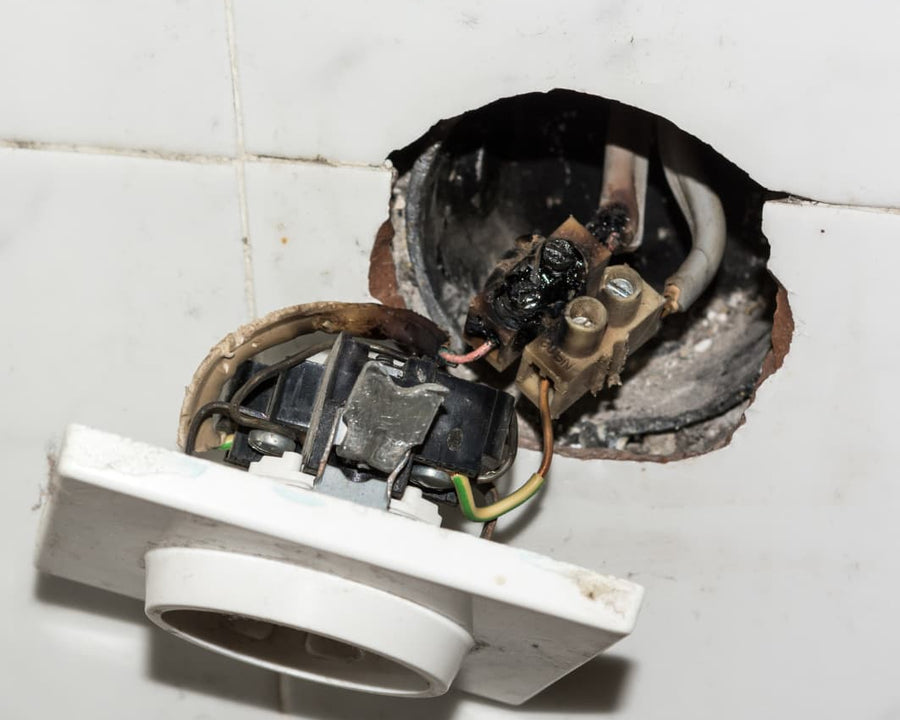 Une prise électrique a cramé qui ressort d'un carrelage