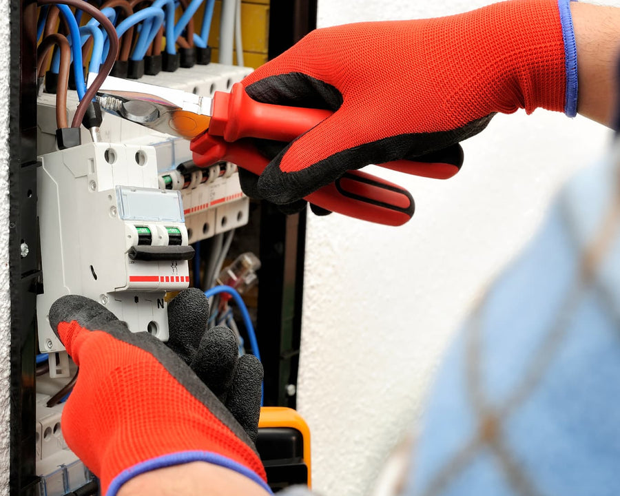 mains gantées avec une pince disjoncteur électrique